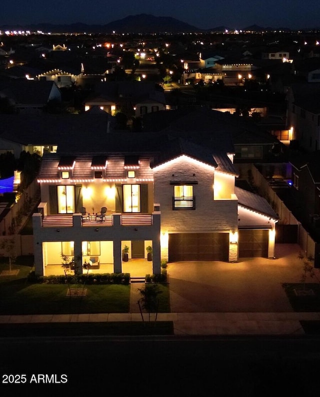 view of front of property featuring an attached garage, a balcony, and concrete driveway