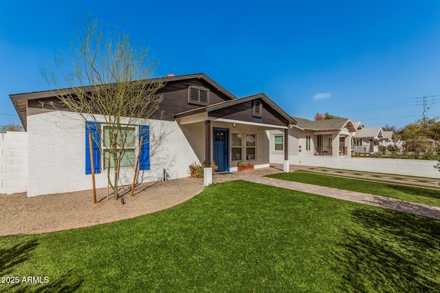 rear view of house with a yard and stucco siding