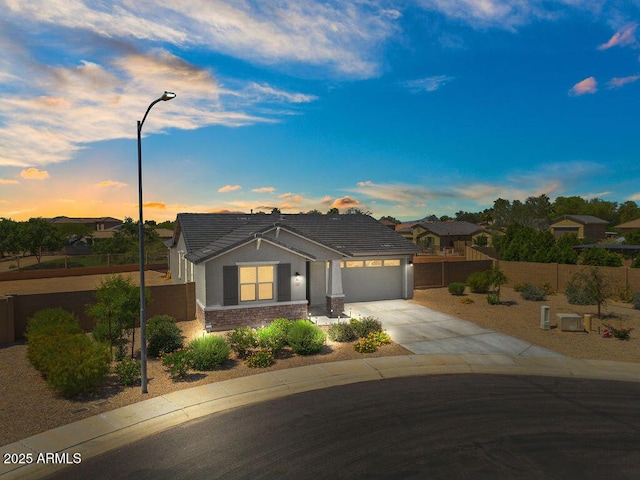 435 E Shellie Ct, Casa Grande, AZ 85122 - view of front of home featuring a tile roof, concrete driveway, an attached garage, stucco siding, and stone siding