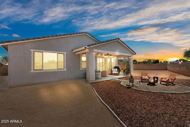 435 E Shellie Ct, Casa Grande, AZ 85122 - back of house at dusk featuring a patio, a fenced backyard, an outdoor fire pit, and stucco siding