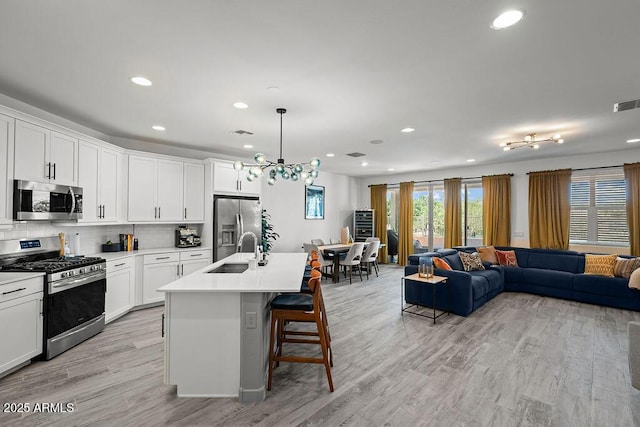 435 E Shellie Ct, Casa Grande, AZ 85122 - kitchen featuring appliances with stainless steel finishes, open floor plan, a sink, recessed lighting, and decorative backsplash