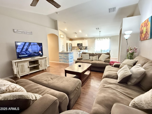 45499 W Sky Ln, Maricopa, AZ 85139 - living room featuring vaulted ceiling, arched walkways, ceiling fan, wood finished floors, and recessed lighting