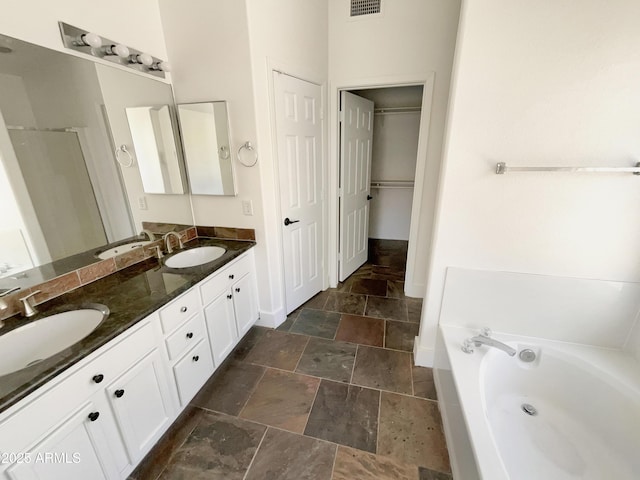 317 E Nunneley Rd, Gilbert, AZ 85296 - full bath with stone tile flooring, double vanity, a garden tub, a shower stall, and a walk in closet