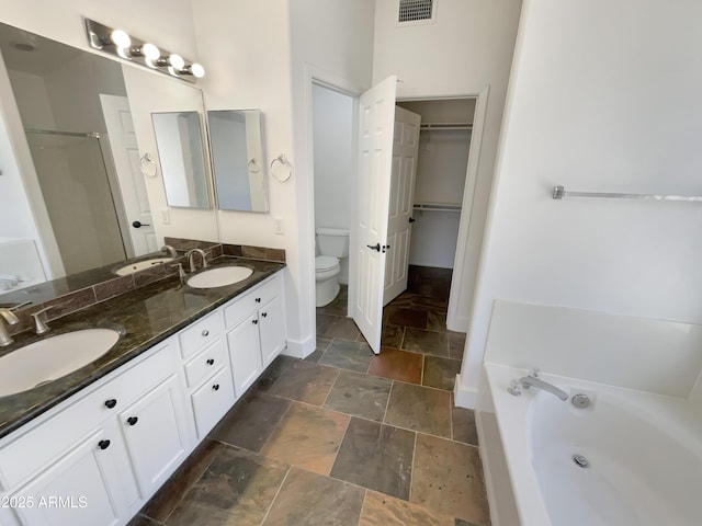 317 E Nunneley Rd, Gilbert, AZ 85296 - full bathroom with stone tile flooring, a bath, double vanity, a shower stall, and a spacious closet