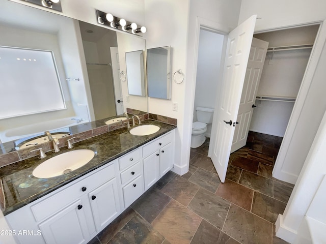 317 E Nunneley Rd, Gilbert, AZ 85296 - full bathroom with stone tile flooring, double vanity, a spacious closet, a tub, and a shower