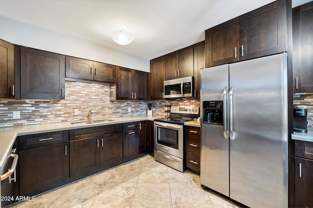 kitchen featuring sink, tasteful backsplash, dark brown cabinets, light tile patterned flooring, and stainless steel appliances