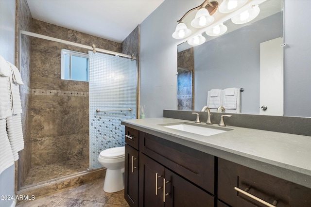 bathroom featuring a tile shower, vanity, and toilet