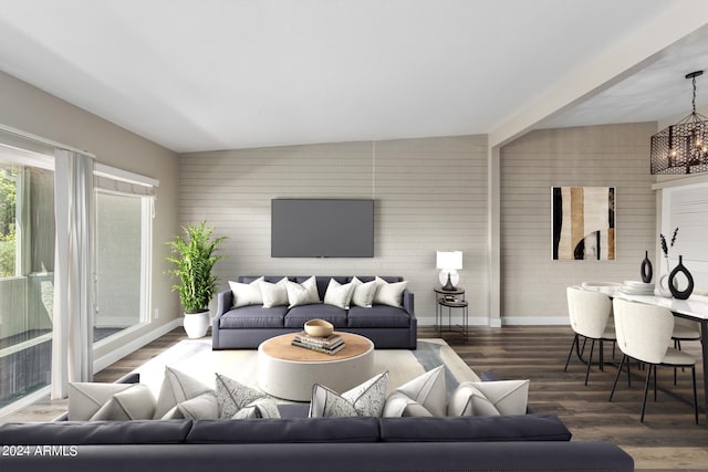 living room featuring a notable chandelier, dark hardwood / wood-style floors, and brick wall