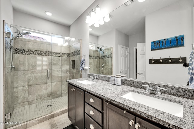 bathroom featuring vanity, a shower with shower door, and tile patterned floors