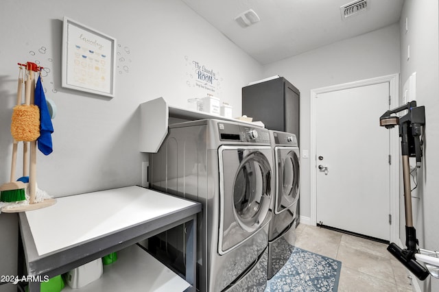 clothes washing area with independent washer and dryer and light tile patterned floors