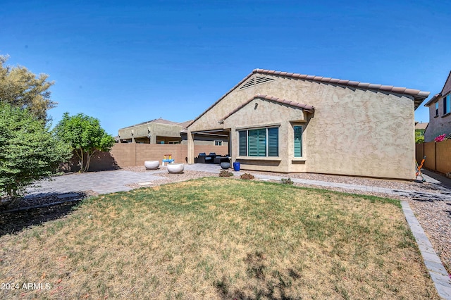 back of property featuring a yard and a patio area