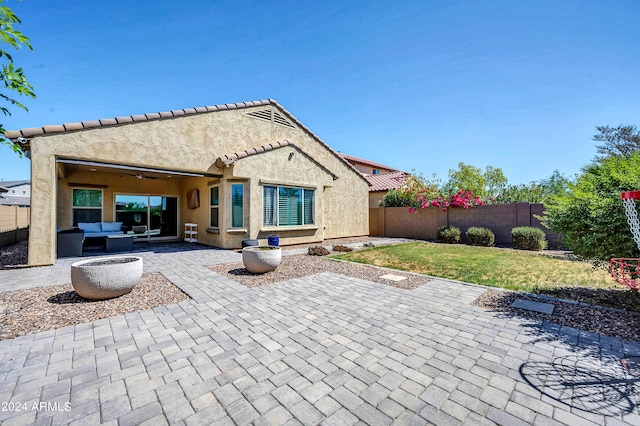 rear view of house featuring a lawn and a patio area