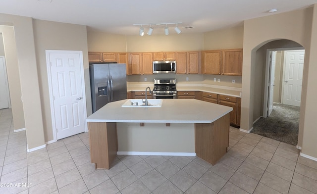 14841 W Desert Hills Dr, Surprise, AZ 85379 - kitchen with appliances with stainless steel finishes, a sink, arched walkways, light countertops, and light tile patterned floors
