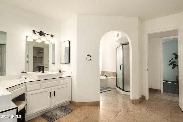 bathroom featuring vanity and independent shower and bath