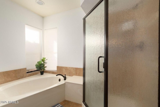 bathroom featuring shower with separate bathtub