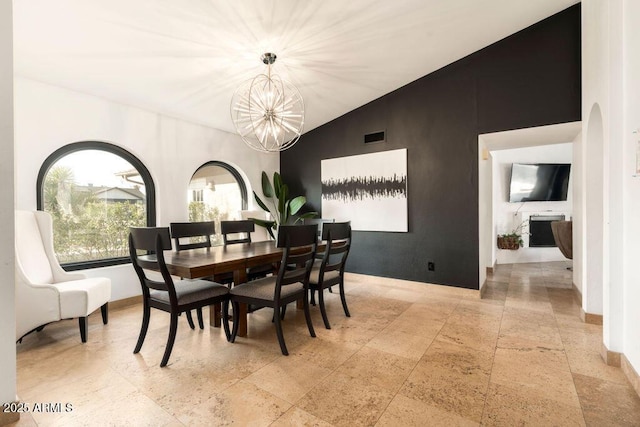 dining area with lofted ceiling and a notable chandelier