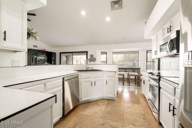 kitchen with appliances with stainless steel finishes, sink, and white cabinets