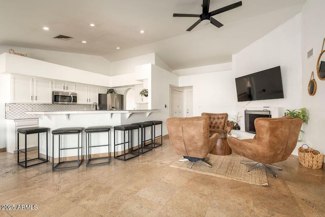 living room featuring vaulted ceiling and ceiling fan