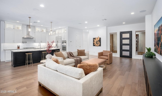 living room with light hardwood / wood-style floors and sink