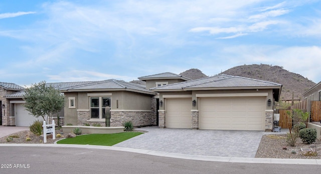 prairie-style home with a garage and a mountain view