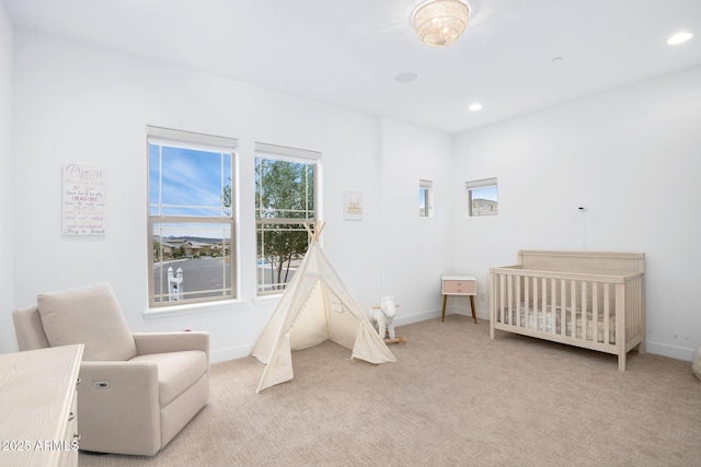 bedroom featuring light carpet and a crib