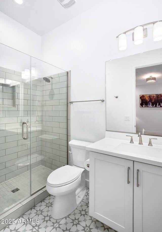 bathroom with a shower with door, vanity, and toilet