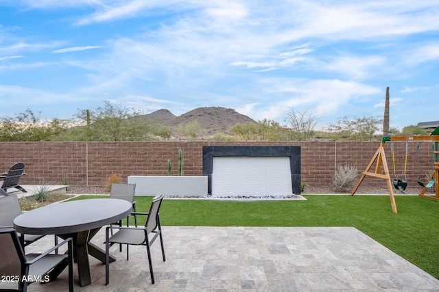 view of patio / terrace featuring a playground and a mountain view