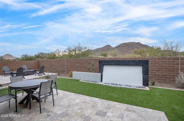 view of patio / terrace with an outdoor fire pit and a mountain view