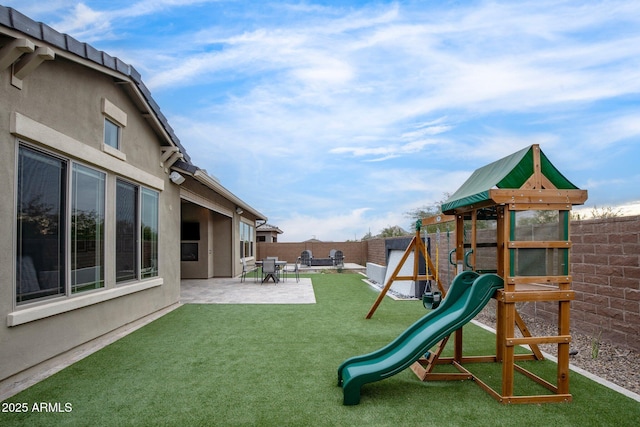 view of jungle gym with a patio and a yard