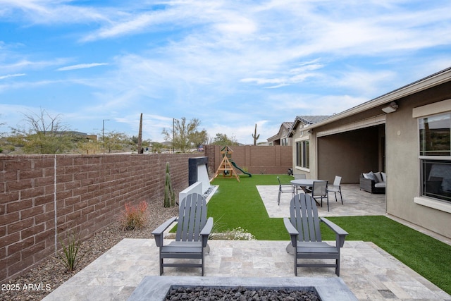 view of patio with an outdoor living space with a fire pit and a playground