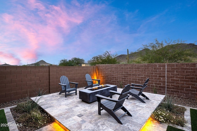 patio terrace at dusk featuring an outdoor fire pit