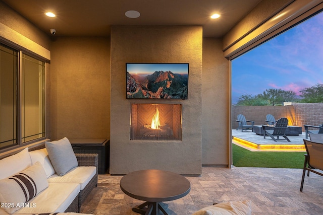 patio terrace at dusk with an outdoor living space with a fireplace