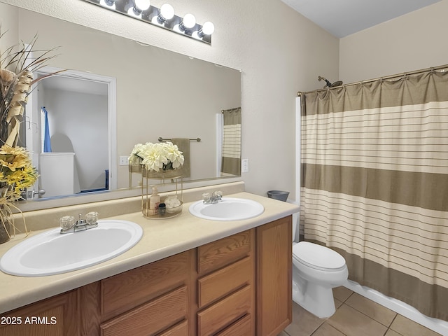 bathroom featuring double vanity, a sink, toilet, and tile patterned floors