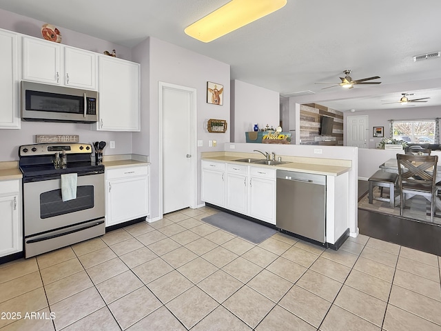 kitchen featuring white cabinets, visible vents, stainless steel appliances, and open floor plan