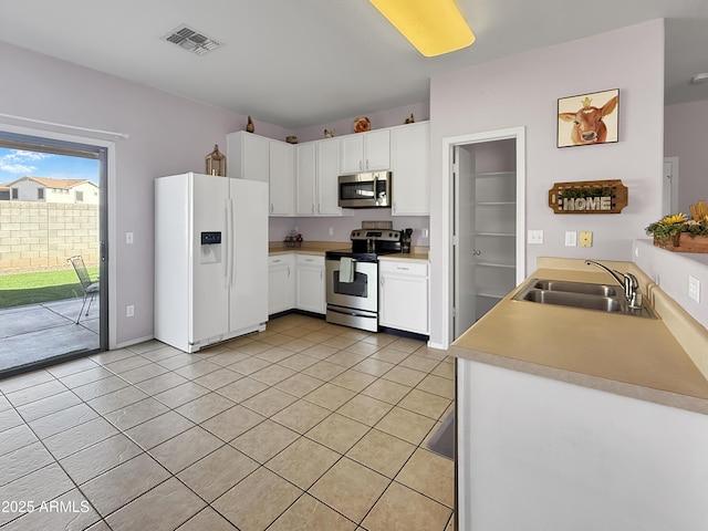 kitchen featuring stainless steel appliances, light countertops, visible vents, white cabinetry, and a sink