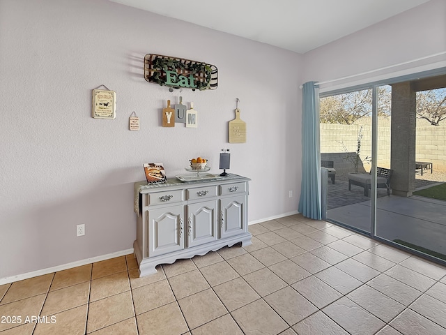 doorway to outside featuring light tile patterned floors and baseboards