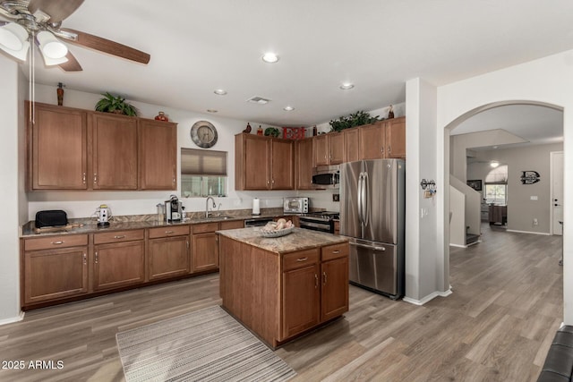 kitchen with a center island, stainless steel appliances, light hardwood / wood-style flooring, and sink