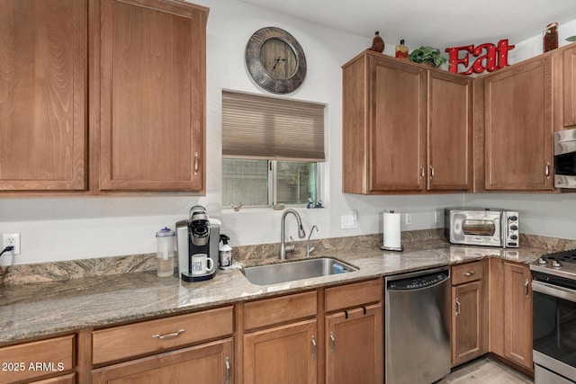 kitchen with light stone counters, sink, and stainless steel appliances