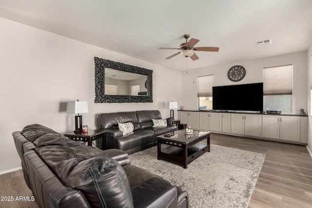 living room with light wood-type flooring and ceiling fan