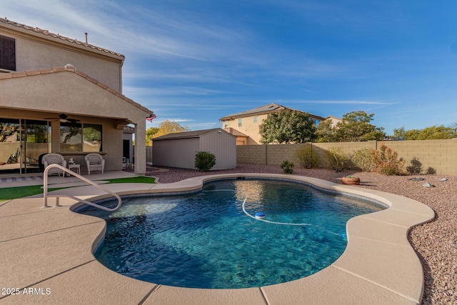 view of pool featuring ceiling fan, a patio area, and a shed