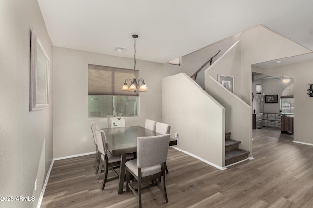 dining area with dark wood-type flooring and a notable chandelier