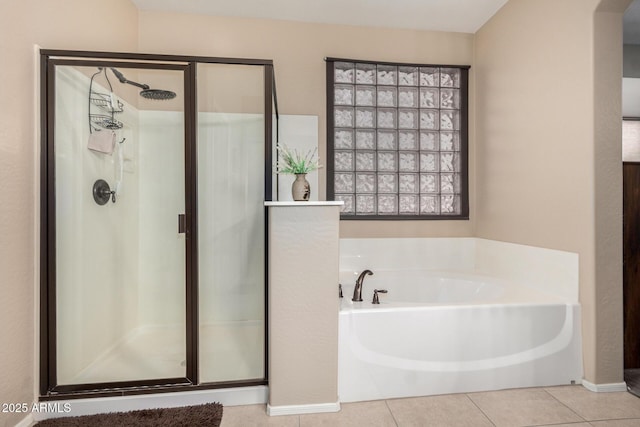 bathroom featuring tile patterned flooring and shower with separate bathtub