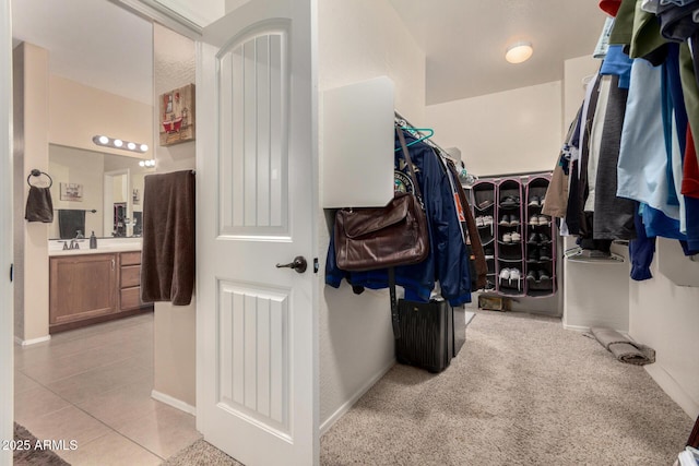 spacious closet featuring light tile patterned floors and sink