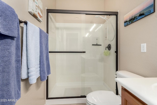 bathroom with vanity, toilet, and a shower with door