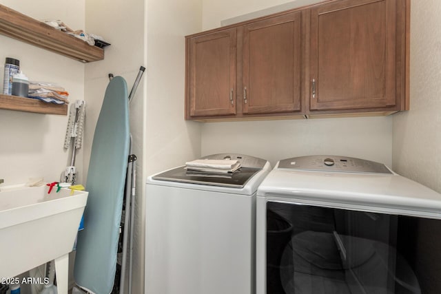 laundry room with washer and dryer, cabinets, and sink