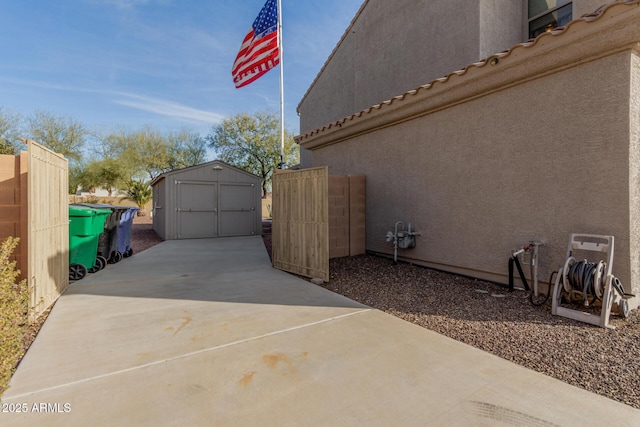 view of side of home with a storage shed and a patio