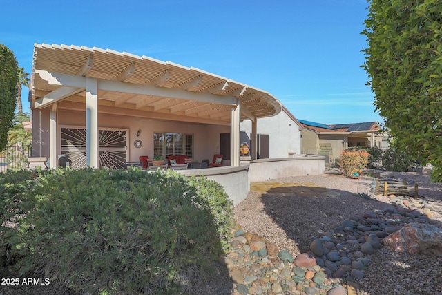 rear view of house featuring a patio and solar panels