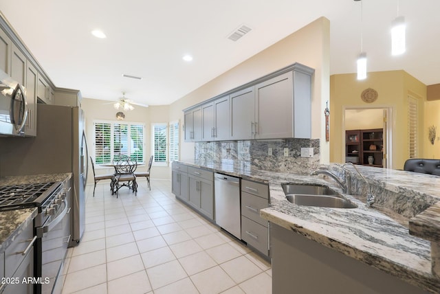 kitchen featuring gray cabinets, appliances with stainless steel finishes, pendant lighting, and dark stone counters