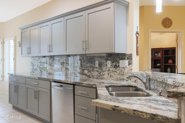 kitchen featuring light stone counters, sink, and gray cabinetry