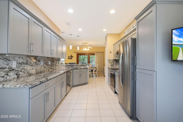 kitchen with pendant lighting, decorative backsplash, stainless steel appliances, and kitchen peninsula